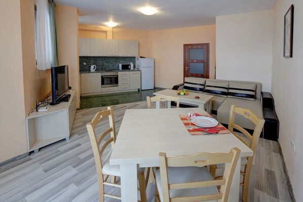 A compact living space with a dining area, kitchenette, and a small seating area. - 1-st Line Izvora Hotel Golden Sands (Golden Sands)