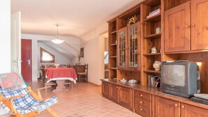 A cozy living room with a wooden cabinet, a television, and a rocking chair.