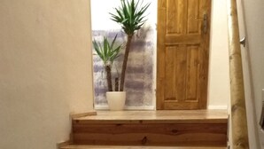 A wooden staircase with a handrail, leading to a wooden door. - Bluebell (Mengusovce)