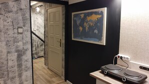 A room with a wooden floor, a white door, a world map on the wall, and a turntable on a table. - Bluebell (Mengusovce)