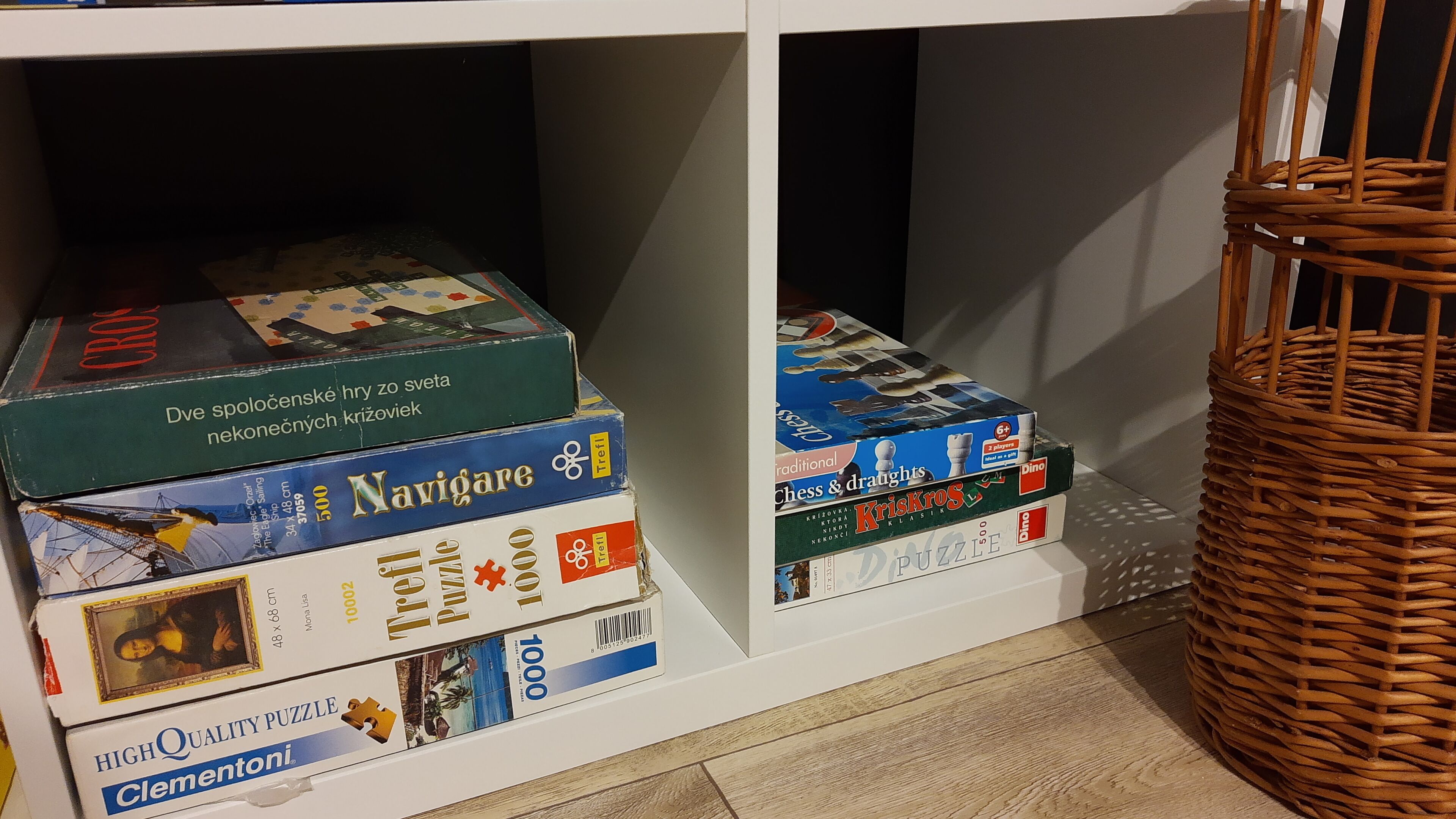 A shelf with various board games and puzzles.