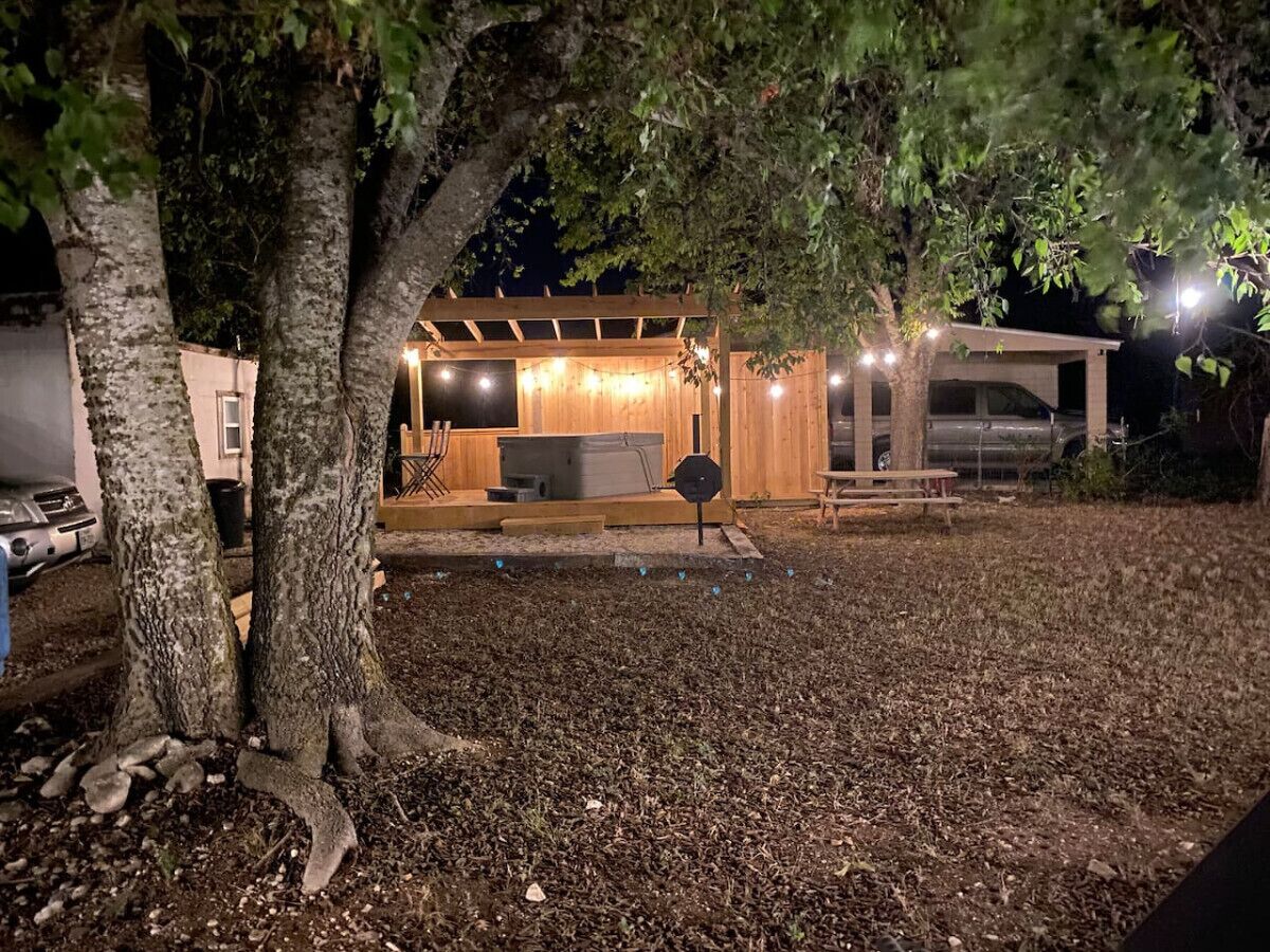 A covered outdoor area with a wooden structure, a bench, and a table.
