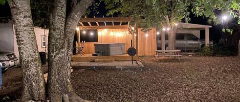 A covered outdoor area with a wooden structure, a bench, and a table.