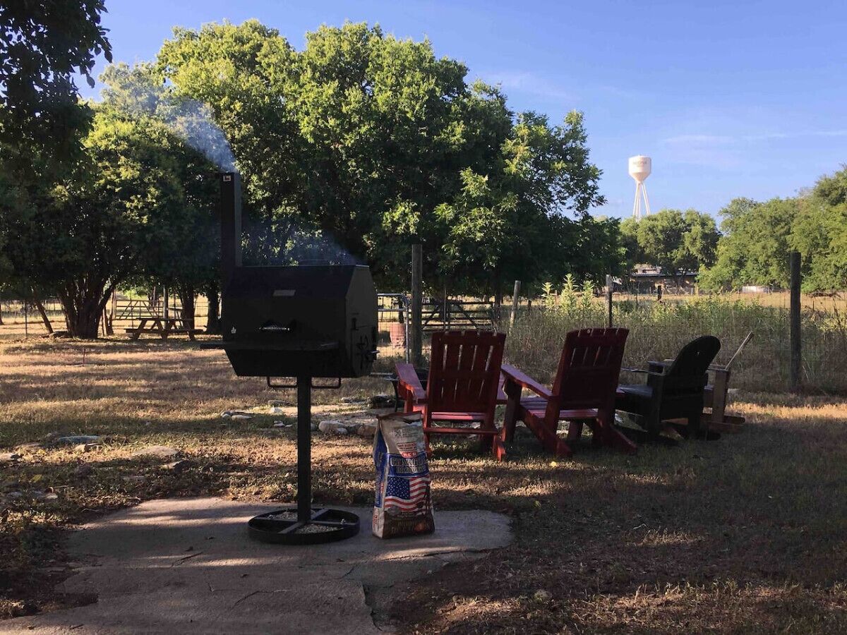 En grill med flag, røde stole og et vandtårn i baggrunden.