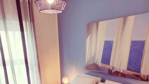 Une chambre moderne avec un grand lit, deux lampes de chevet et un luminaire suspendu.
