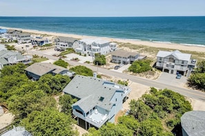Stunning coastal homes with gabled and flat roofs, surrounded by lush greenery and offering scenic ocean views.