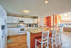 Enjoy cooking in this well-equipped kitchen with a central island, microwave, and stove.
