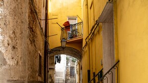 Un estrecho callejón adoquinado con una escalera que lleva a un edificio amarillo.