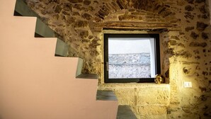 Una escalera de piedra que lleva a una ventana con vistas a un paisaje rocoso.