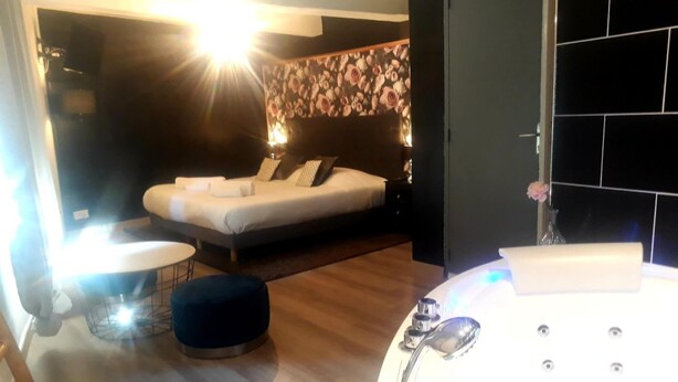 A modern bathroom with a large bathtub, a toilet, and a sink. - Hôtel Renaissance Martigues (Martigues)