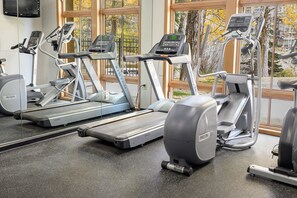 A gym with treadmills and elliptical machines, large windows, and a view of trees and buildings outside. - 110 Ft to Gondola | Ski-In/Out | Hot Tub (Winter Park)