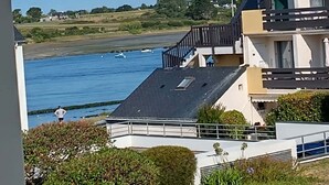 Un edificio moderno con tetto piatto e un balcone con vista sull'acqua.