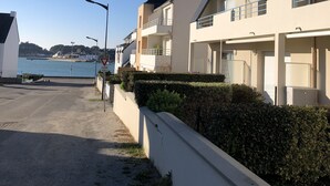 Una zona residenziale sulla costa con case moderne, cielo sereno e vista sul mare.
