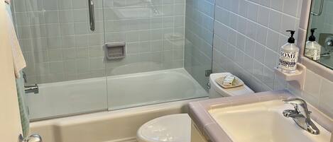 A bathroom with a bathtub, toilet, and sink.