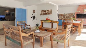 Un espace repas avec des meubles en bois, une cheminée et une cuisine en arrière-plan.