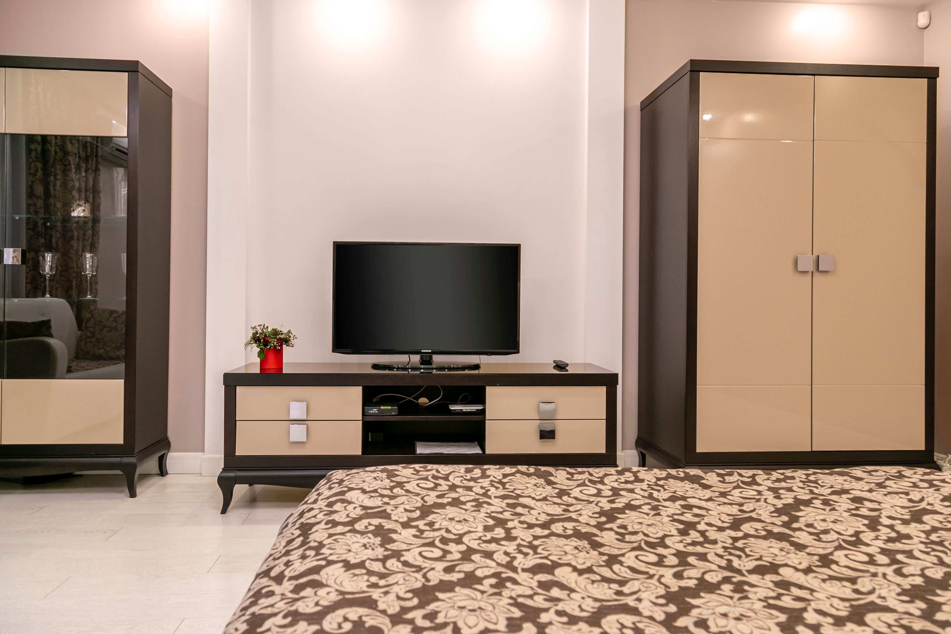 Un dormitorio con una cama, un televisor sobre una cómoda y un armario.