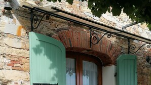 A rustic stone building with a wooden door, green shutters, and a potted plant. - LAST-MINUTE!FANTASTIC PART OF RUSTIC IN THE VIEW ONLACOLLINE WITH PRIVATE POOL (Massarosa)