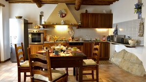 A rustic kitchen with wooden cabinets, a dining table with chairs, and various kitchen appliances. - LAST-MINUTE!FANTASTIC PART OF RUSTIC IN THE VIEW ONLACOLLINE WITH PRIVATE POOL (Massarosa)