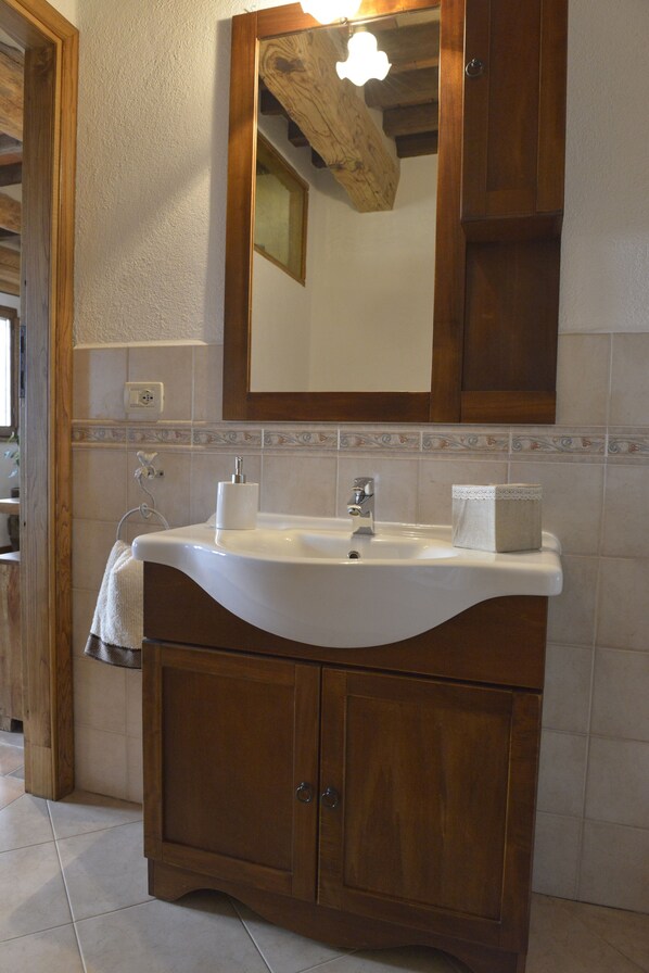 Une salle de bain avec un meuble-lavabo en bois, un évier et un miroir.