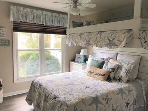 Relax in this cozy Bethany Beach retreat with a large bed, ceiling fan, and nautical-themed decor.