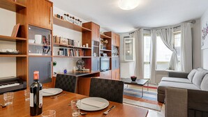 Ein modernes Wohnzimmer mit Essbereich, Holzmöbeln und einem Klavier.