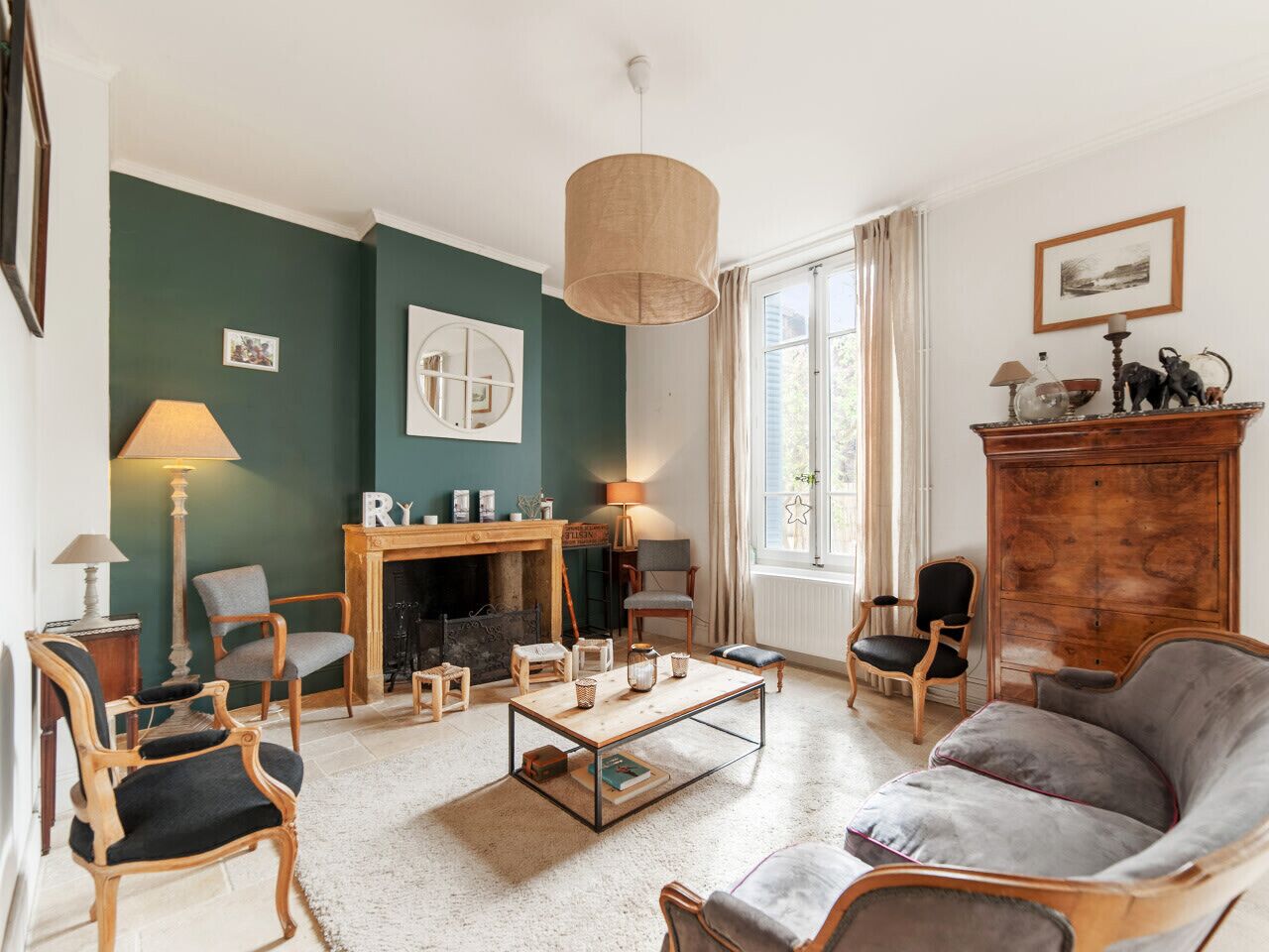 Una sala de estar acogedora con chimenea, asientos cómodos y un ventanal con cortinas.