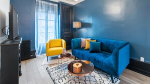 A modern living room with a blue sofa, a yellow armchair, and a coffee table. - Appartement Majorel - Welkeys (Lyon)