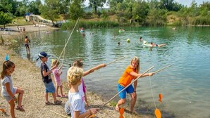 A group of people fishing by a lake with a water slide in the background. - Comfortable 3 bedroom mobile home with air conditioning in Provence - Swimming pool and private lake (La Roque-d'Anthéron)