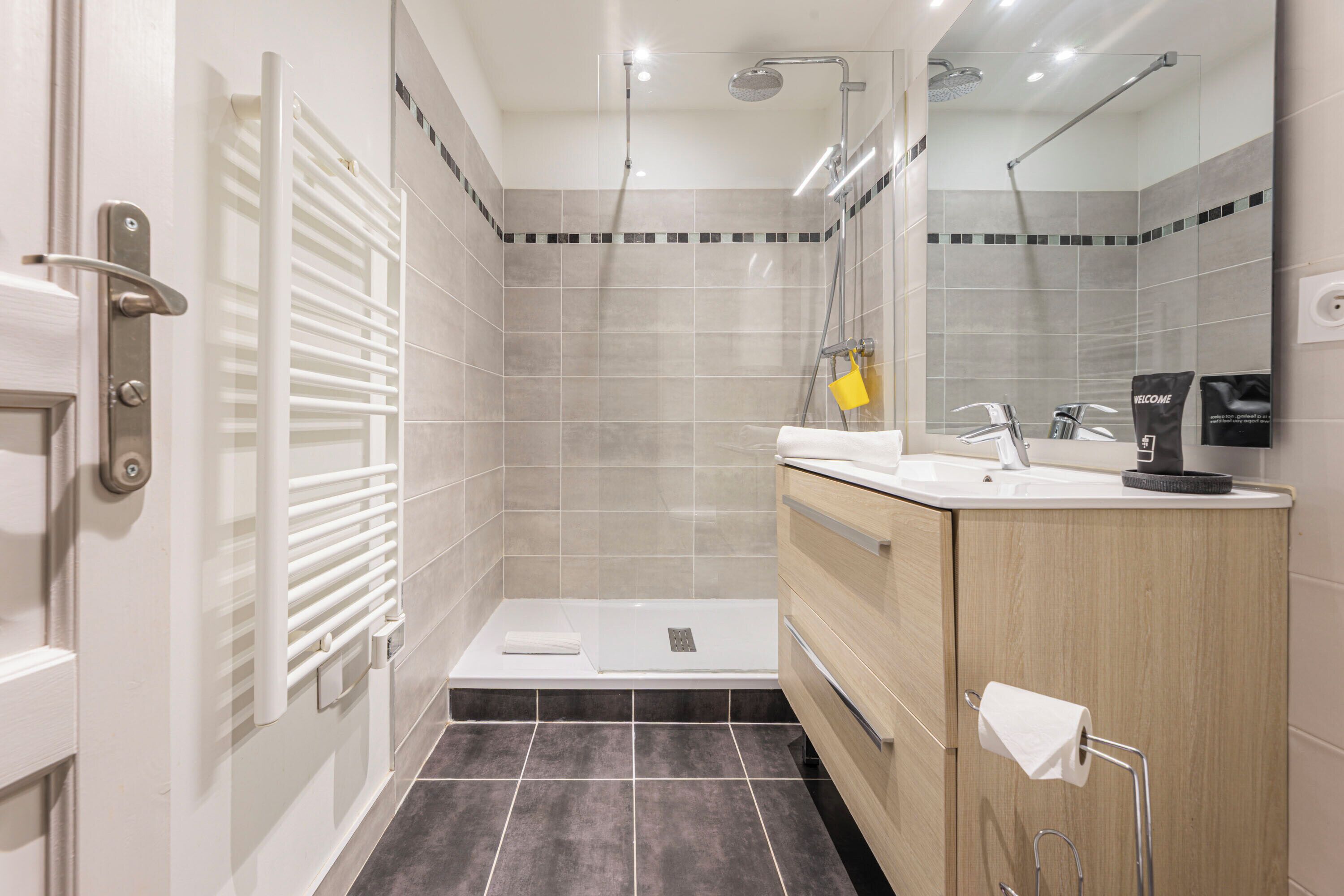 A modern bathroom with a shower, a sink, and a toilet.
