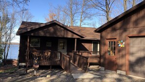 Een chalet met een veranda, een garage en een bord waarop staat dat het een chalet is.