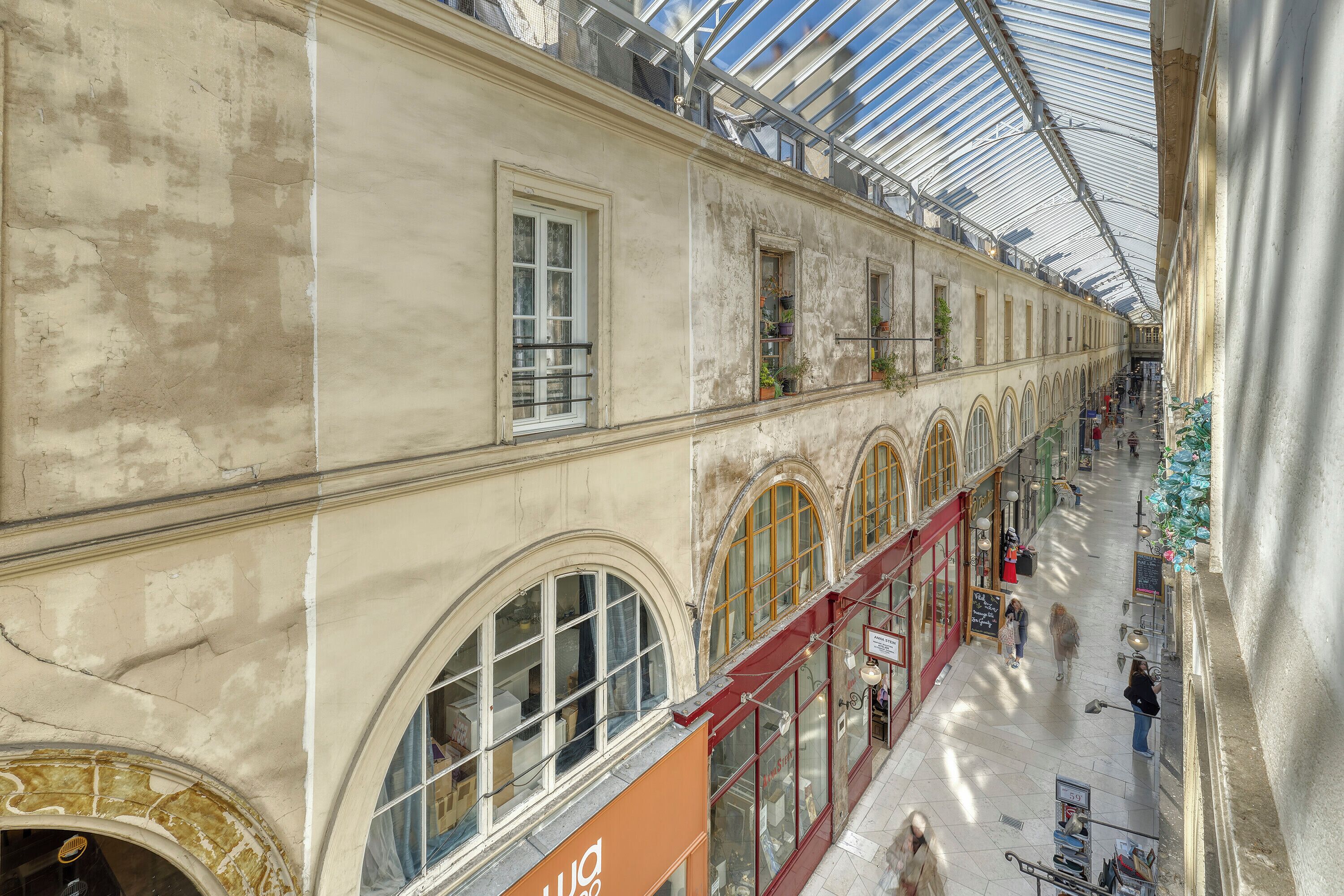 Ein Innenraum eines historischen Gebäudes mit Bogenfenstern und einer Glasdecke.