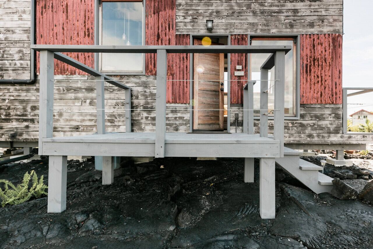 Ett rustikt trähus med en balkong och en dörr.