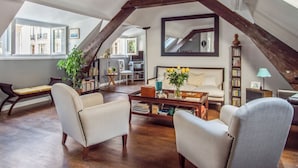 Un loft espacioso con techos altos, vigas de madera a la vista y ventanas amplias.