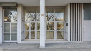 A building entrance with a glass door, a set of stairs, and a number '151' above the door.