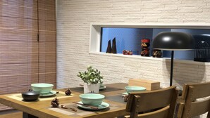 A dining area with a wooden table, chairs, and a window with decorative items.