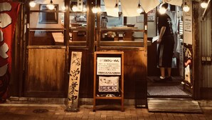 A restaurant with a wooden exterior and a sign with Japanese characters.