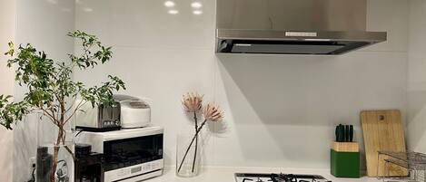 A modern kitchen with a gas stove, a microwave, and a built-in oven.