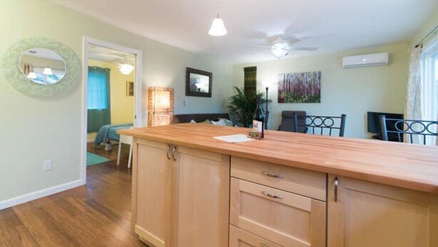 A kitchen with wooden cabinets, a countertop, and a ceiling fan. - Light and bright family-friendly cottage (Portland)