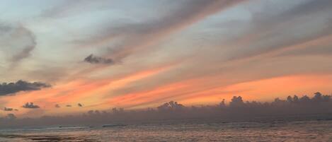 A coastal sunset with a clear sky and calm sea.