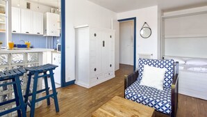 Eine moderne Küche mit weißen Schränken, einer Holzauskładung und einem blauen Barhocker.