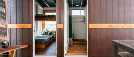 Un intérieur en bois avec un lit superposé, un banc et une table.