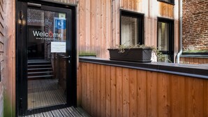 A wooden exterior with a black door and a sign that reads "Welcome". - Vieille Bourse - Studio close to stations and old city - Welkeys (Lille)
