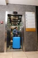 Un ascensor con un cartel que indica el piso 1, San Jose, y una recepción/vestíbulo.