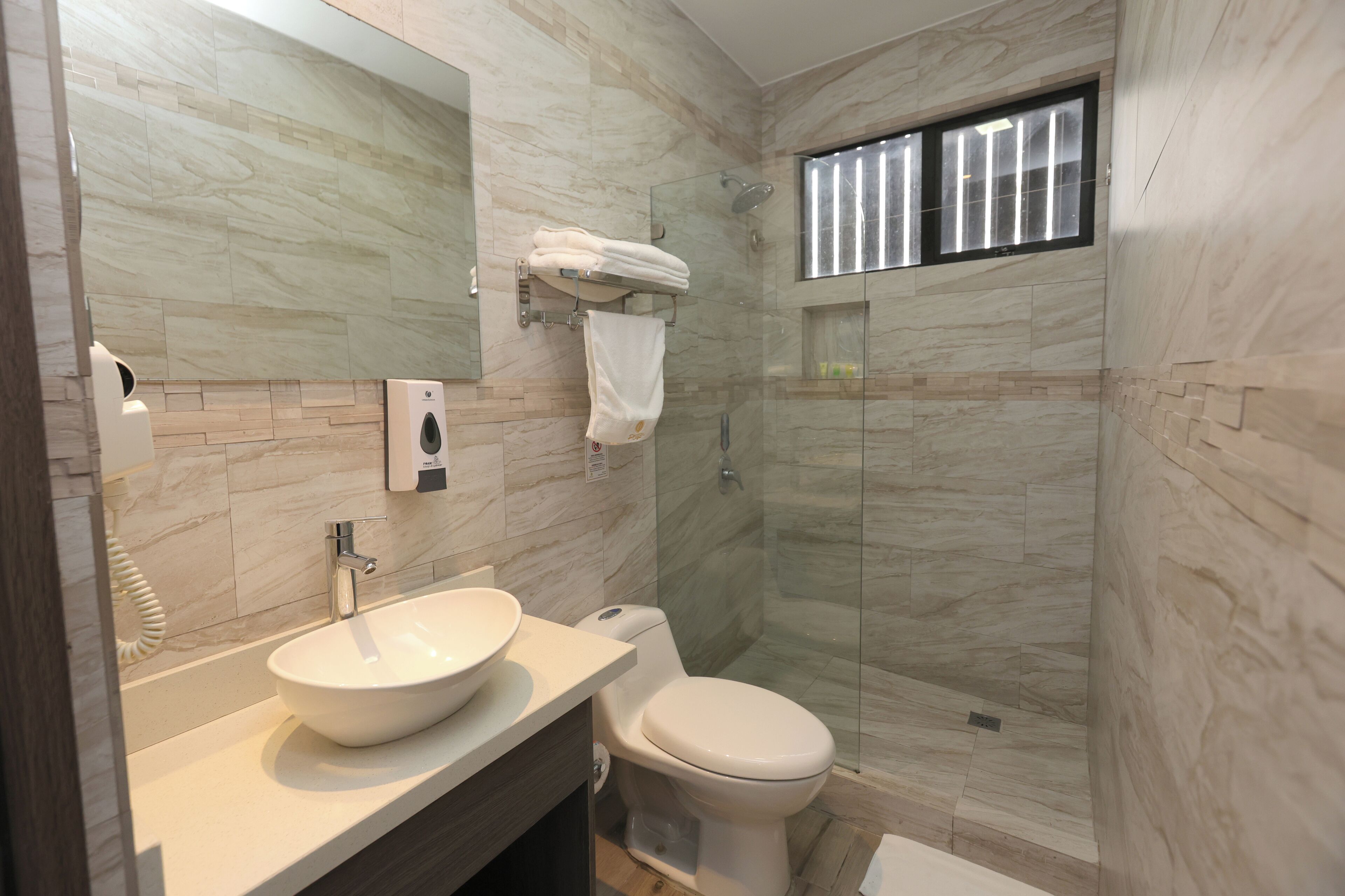 Ein modernes Badezimmer mit einem großen Waschbecken, Toilette und einer Duschkabine aus Glas.
