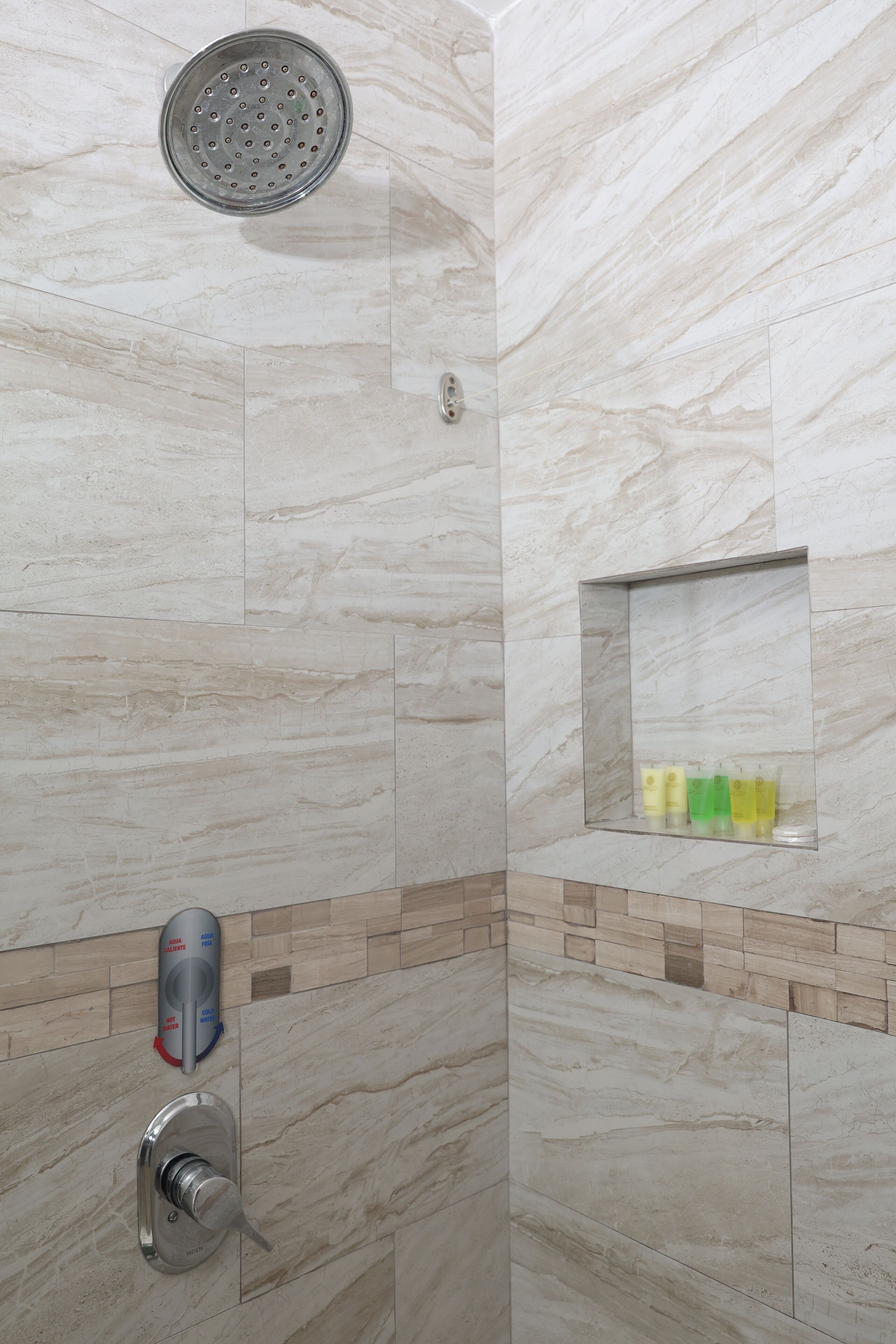 Ducha con cabezal de ducha de mano y panel de control.