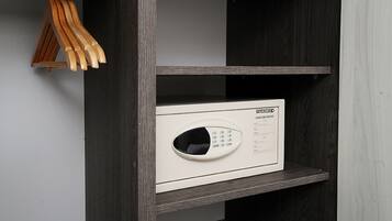 A microwave oven with a control panel and a small instruction manual on a shelf.