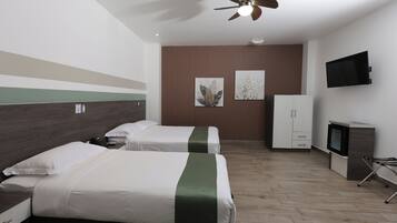 Ein Hotelzimmer mit zwei Betten, einem Deckenventilator, einem Flachbildfernseher und einem Schrank.