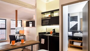 A compact hotel room with a kitchenette, a dining area, and a bathroom. - Beffroi - Cosy studio close to Vieux Lille - Welkeys (Lille)