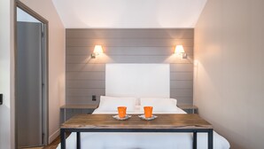 A hotel room with a bed, two bedside tables, and two lamps. - Beffroi - Cosy studio close to Vieux Lille - Welkeys (Lille)