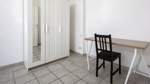 A room with a white wardrobe, a wooden desk, and a black chair. - Triplex Laharie - Welkeys (Bayonne)